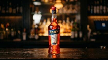 Aperol Italian aperitif bottle on a dark bar.