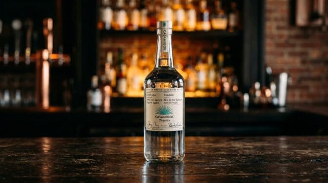 Casamigos Blanco tequila bottle on a dark bar.