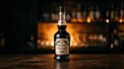 Lejay Crème de Cassis blackcurrant liqueur bottle on a dark bar.