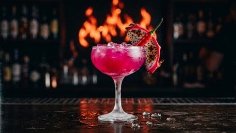 Tropical dragon fruit rum cocktail with chili and dragon fruit garnish