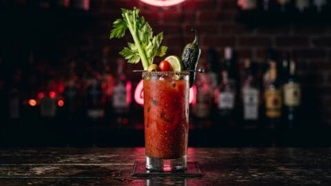 Spicy Bloody Mary with charred jalapeno, black pepper rim, and toothpick teeth