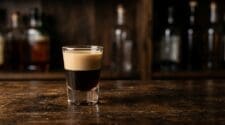 Muddy Water layered shot of coffee liqueur and cream on a dark wooden bar
