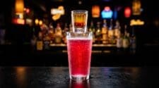 Vegas Bomb shot with Crown Royal and peach schnapps in a shot glass over a pint glass of Red Bull and cranberry